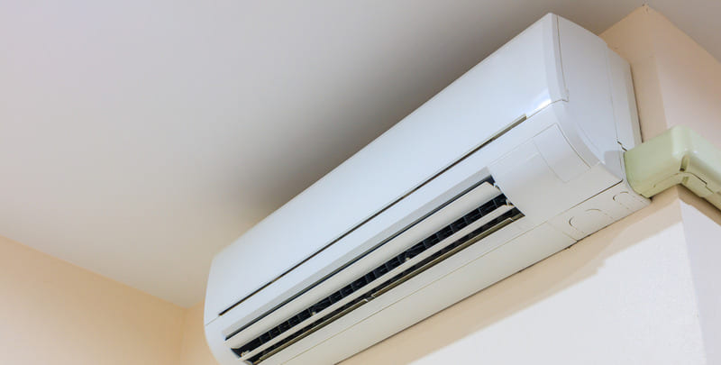 Indoor unit of a split system air conditioner installed in the top corner of a wall.