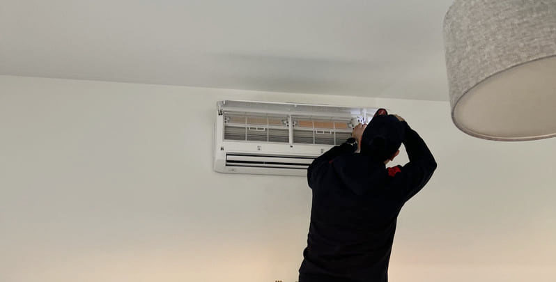 professional air conditioning technician installing indoor unit of multi head split system air conditioner